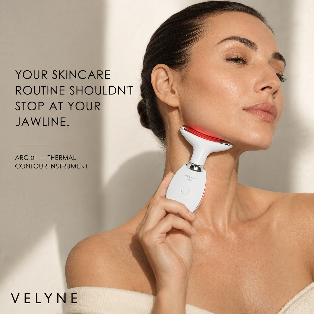 A woman holding VELYNE ARC 01 at her jawline; skincare for face, jawline and neck